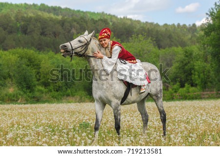 Girl in national costume, Tatar. Girl on a horse. Field with dandelions. Sabantuy National Holiday