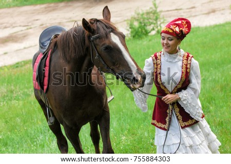 Girl in national costume, Tatar. Girl on a horse. Field with dandelions. Sabantuy National Holiday