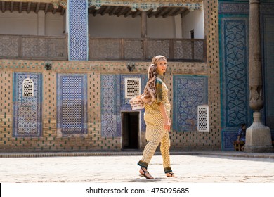 The girl in national costume of Uzbekistan, on the background of madrassas