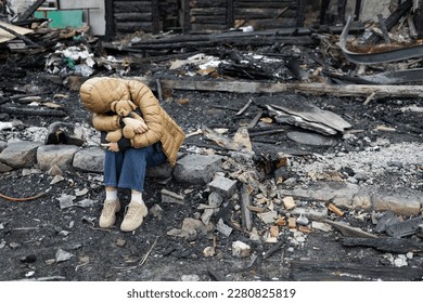 A girl next to a house destroyed by the war. War in Ukraine. Ukrainian refugees. Child in the ruins of his house destroyed by the war. Peace concept