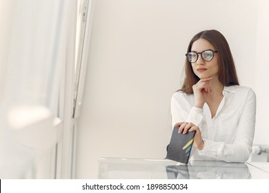Girl in a office. Woman in a white shirt. Lady use the notebook.