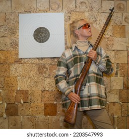 A Girl With An Old Rifle In A Shooting Range At A Target For Shooting.