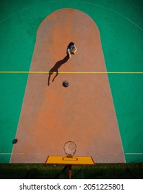 ein Mädchen auf einem Basketballplatz wirft einen Ball