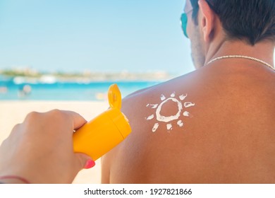 The girl on the beach applies sunscreen to the skin of a man. Selective focus. nature.
