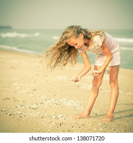 Girl On The Beach Collecting Shells