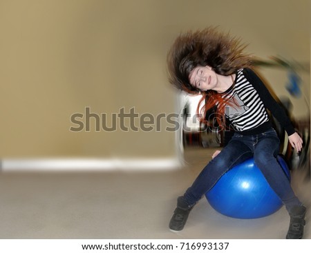 Girl on exercise ball flipping hair