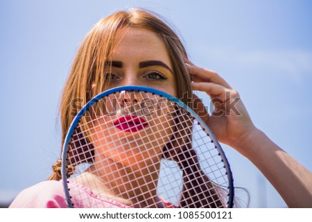 A girl on the football field plays a game of badminton