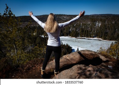 Girl On A Hill Looking Out On A Canadian Winter Lake