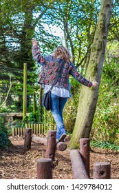 Girl On Holiday Having Fun Trying To Cross The Balance Beam Without Falling Off