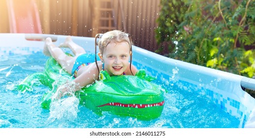 Girl On Inflatable Crocodile Float In Outdoor Swimming Pool At Home. Summer Recreation With Kids. Water Toys. Little Child Floating On Colorful Raft.