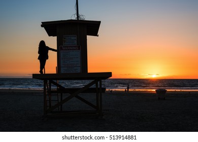 Girl On A Lifeguard Tower In Newport Beach At Sunset, California