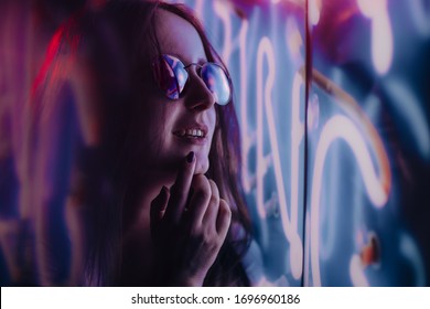 girl on a night street in purple light of a neon sign. life of the night city. neon lights at night. night woman portrait. fashion model posing in neon light - Shutterstock ID 1696960186