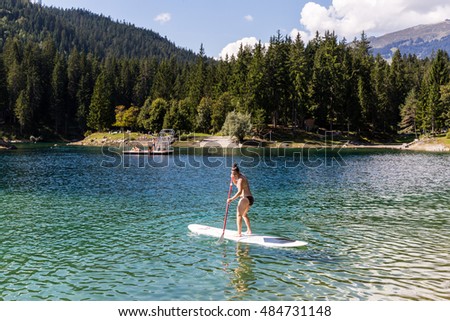 Girl on a paddleboard on the Caumasee in Flims, Switzerland