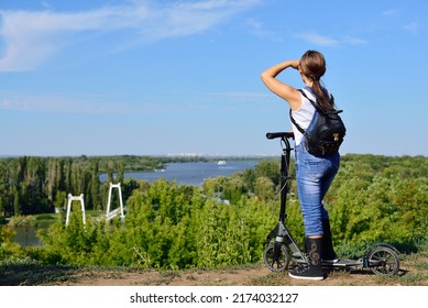 Girl on a scooter looking at a beautiful landscape