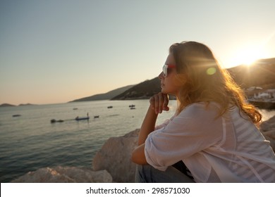 Girl on the seashore watching the sunset
