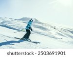 Girl On the Ski. Active winter holidays, skiing downhill in sunny day. Woman skier alone fast ski on steep hill downhill