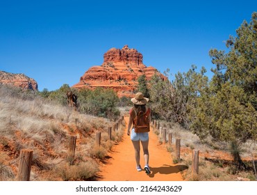 Girl on spring hiking trip in red mountains. Woman walking on pathway on Bell Rock Loop. Bell Rock is a butte just north of Village of Oak Creek, Arizona, south of Sedona in Yavapai County.USA.