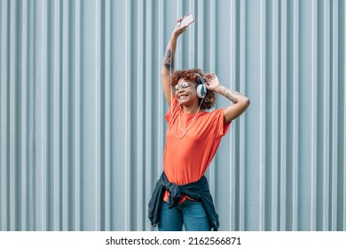 Girl On The Street Dancing With Headphones And Mobile Phone Or Smartphone