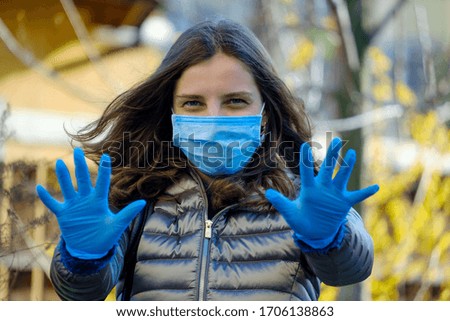 Girl on the street during an outbreak of coronavirus. Woman in a mask and rubber medical gloves. Quarantine Prevention.
