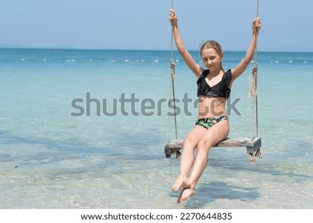 girl on a swing near the sea, blue sea