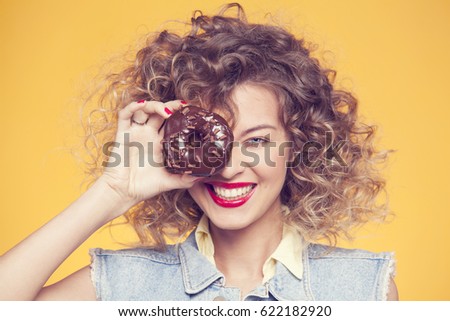 girl on a yellow background, looking across the hole from a choc