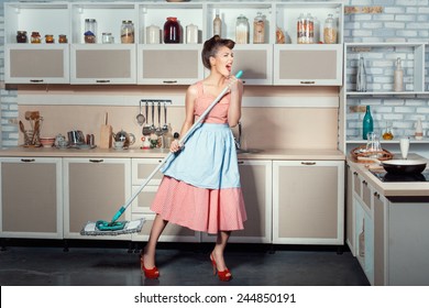 The girl opened her mouth much because when she sings cleans the kitchen. She carried a mop for washing floors.