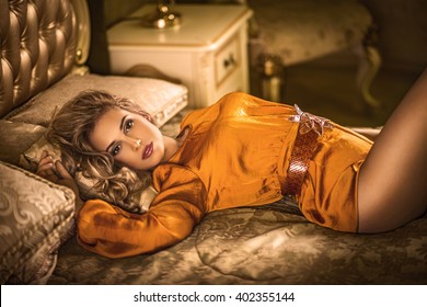 Girl In Orange Dress On The Bed