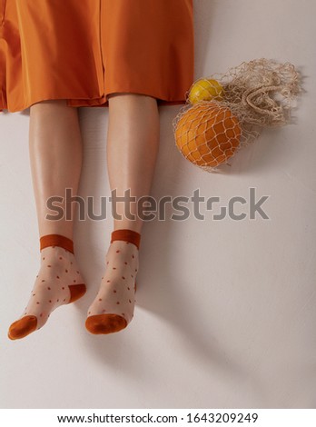 
Girl in an orange trench coat with melon and lemon