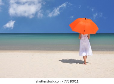 Girl With An Orange Umbrella On The Sandy Beach