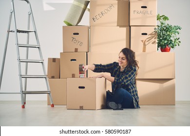 Girl organizes boxes in a new apartment