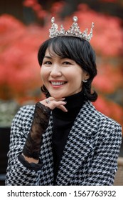 A Girl Of Oriental Nationality In A Crown And Fishnet Gloves, Laughing Playfully