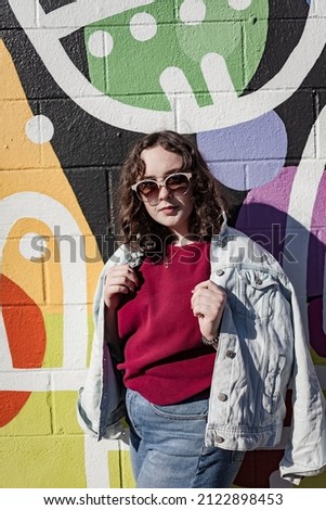 girl outside with mural behind, sunny photos with bright colors