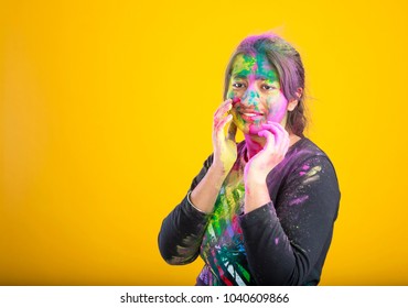 girl painted her face with multi colors and celebrating indian festival holi