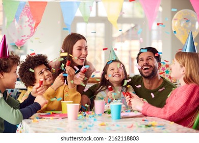 Girl With Parents And Friends At Home Celebrating Birthday Firing Confetti Poppers At Party - Powered by Shutterstock