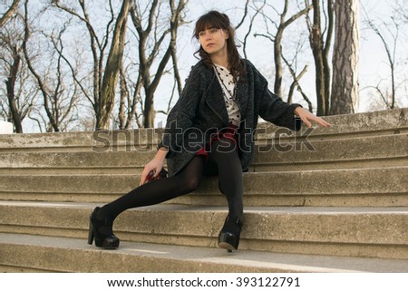 Similar – Junge Frau sitzt auf einer Bank in einem Park in ruhiger Pose.