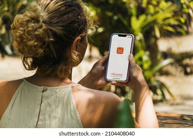 Girl In The Park Holding A Smartphone With Ali Express App On The Screen. Rustic Wooden Table. Rio De Janeiro, RJ, Brazil. January 2022.