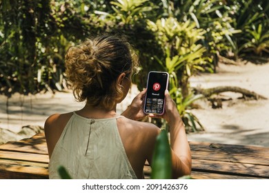 Girl In The Park Holding A Smartphone With Pinterest App On The Screen. Rio De Janeiro, RJ, Brazil. December 2021.