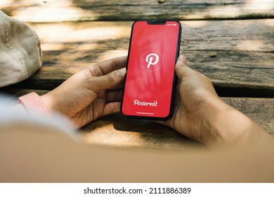 Girl In The Park Holding A Smartphone With Pinterest App On The Screen. Rustic Wooden Table. Rio De Janeiro, RJ, Brazil. January 2022.