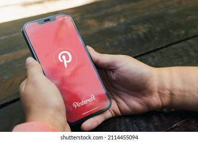 Girl In The Park Holding A Smartphone With Pinterest App On The Screen. Rustic Wooden Table. Rio De Janeiro, RJ, Brazil. January 2022.