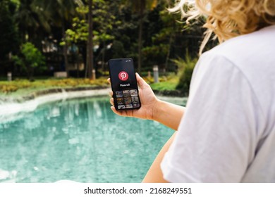 Girl In The Park Holding A Smartphone With Pinterest App On The Screen. Rio De Janeiro, RJ, Brazil. May 2022.