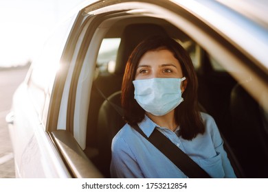 Girl Passenger In Protective Sterile Medical Mask In The Taxi Car During An Epidemic In Quarantine City. Health Protection, Safety And Pandemic Concept. Covid - 19. 