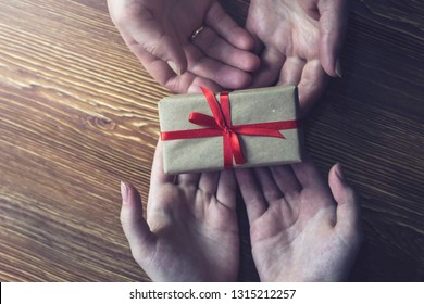 Girl passes a gift with a red ribbon woman