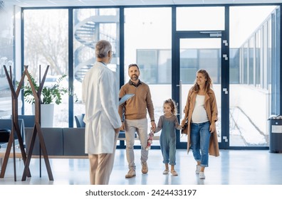 Girl patient looking forward to her doctor and examination in a modern clinic. Girl arriving in hospital with her parents. Emotional support during medical examination. - Powered by Shutterstock