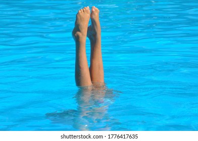 Girl Performing Synchronised Swimming And Diving In Blue Water