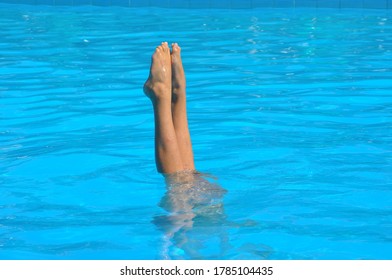 Girl Performing Synchronised Swimming And Diving In Blue Water