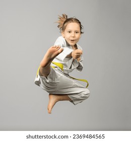 girl performs martial arts flying kick, studio shot - Powered by Shutterstock