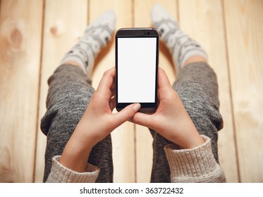 Girl With A Phone In Her Hands Sitting On The Wooden Floor.
Top View