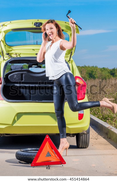 girl\
with phone and wrench is waiting roadside\
assistance
