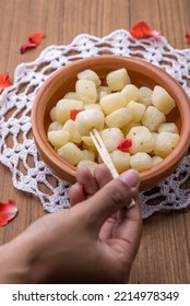 A girl picking up Chena Murki in a bowl, Chena Murki is a bite-size dry sweet made with paneer dipped in sugar syrup  - Shutterstock ID 2214978349