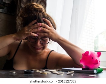 A Girl With A Piggy Bank, She Has No Money, She Looks At Pennies And Cries. Counts Expenses And Utilities, Poverty